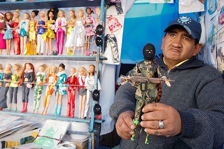 The seller shows a figure of special operations soldier, the toy that represents someone’s dream to become a well-paid counter-terrorist pro.